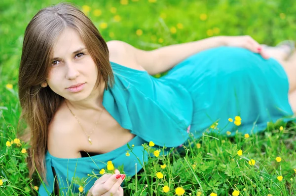 Krásná mladá dívka ležela v trávě — Stock fotografie
