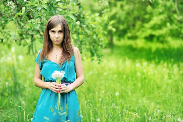 Dandelions bir parkta genç kızla — Stok fotoğraf