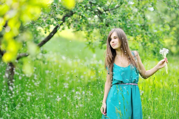 Girl with a dandelions outdoors — Stock Photo, Image