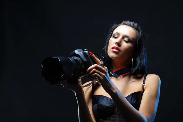 Женщина смотрит на новую цифровую камеру с удивлением и интерьером — стоковое фото