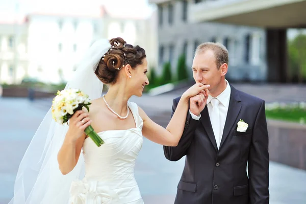 Vőlegény menyasszony kéz csók együtt járás közben — Stock Fotó