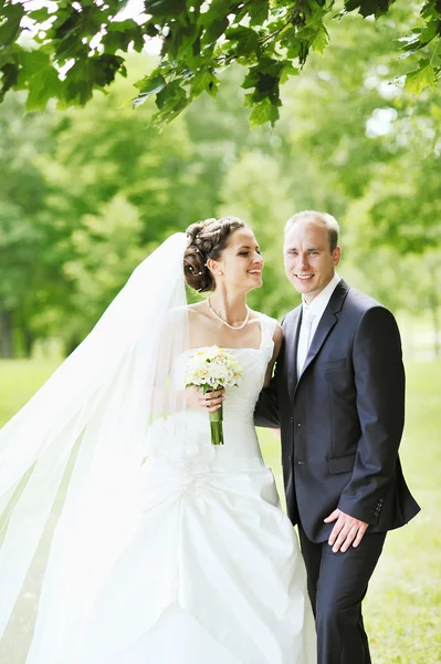 Porträtt av lyckliga bruden och brudgummen i en park — Stockfoto