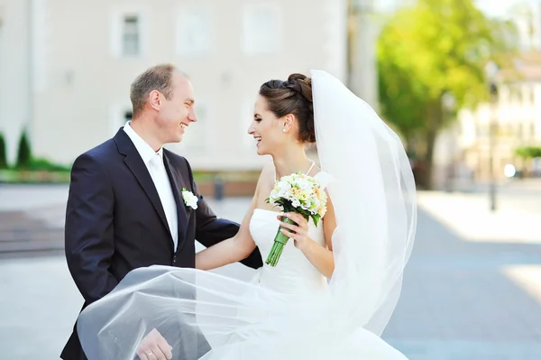 Mladý šťastný ženich a nevěsta se dobře baví ve starém městě — Stock fotografie
