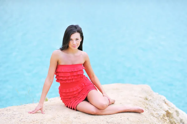 Jovem mulher bonita em uma praia olhando para você — Fotografia de Stock