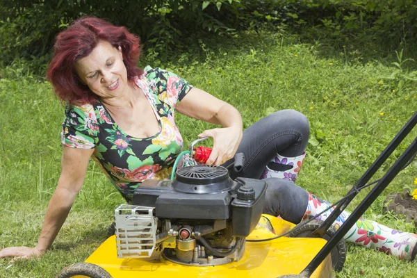 Smilling women oiling lawn mower — Stock Photo, Image