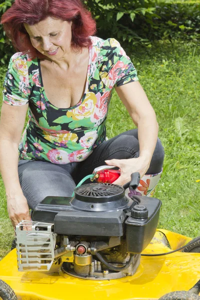 芝生の発動機を給油 smilling 女性 — ストック写真