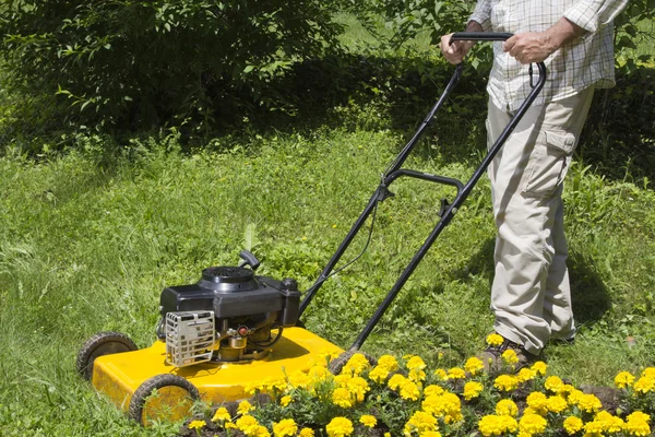 Homem com cortador de grama amarelo — Fotografia de Stock