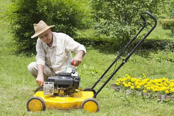 Mitten av ålder man reparera gräsklippare — Stockfoto