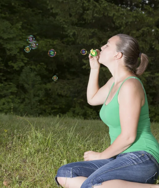Cute girl blowing colorful bubbles — Stock Photo, Image
