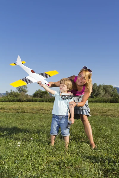 Schattig moeder, jonge zoon en rc vliegtuig — Stockfoto