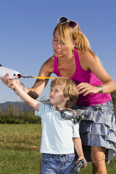 Niedliche Mutter, kleiner Sohn und rc Flugzeug — Stockfoto