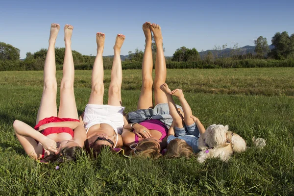 ¡Arriba las piernas! Novias y niñito disfrutando de la soleada tarde de verano al aire libre —  Fotos de Stock