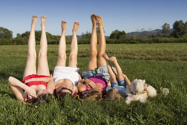 Les jambes en l'air ! Copines et petit garçon profitant de l'après-midi d'été ensoleillé en plein air — Photo