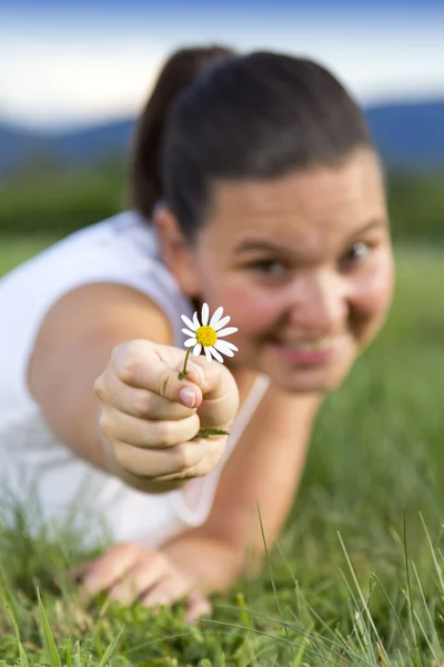 Söta leende flicka med en daisy — Stockfoto