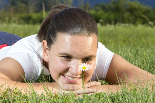 Cute smiling girl with a daisy — Stock Photo, Image
