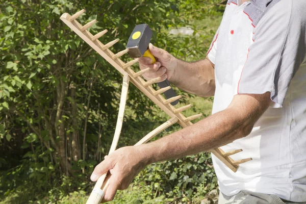 Herstellen van houten hark in de tuin — Stockfoto