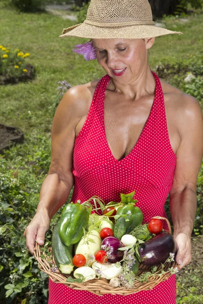 Smilling mid age woman with fresh picked vegetables — Stock Photo, Image