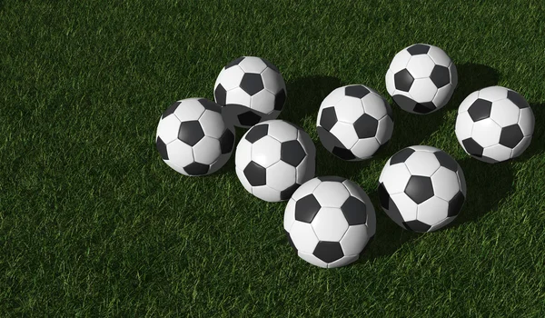 Футбольні м'ячі на зеленому газоні — стокове фото