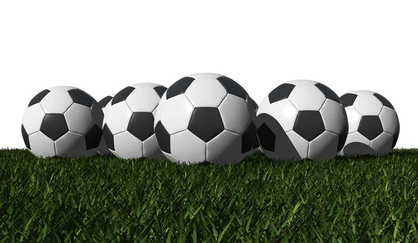 Футбольні м'ячі на зеленій траві — стокове фото