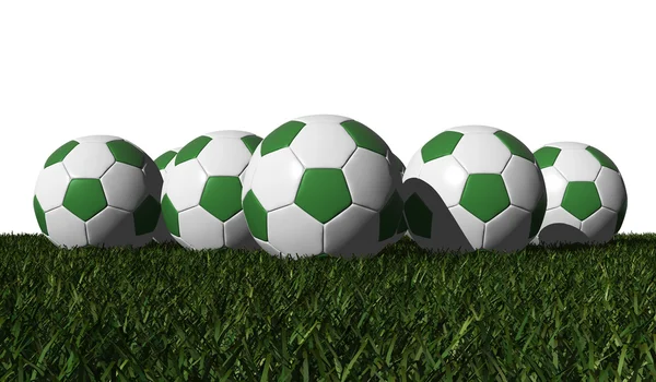 Зеленые футбольные мячи на зеленой траве — стоковое фото