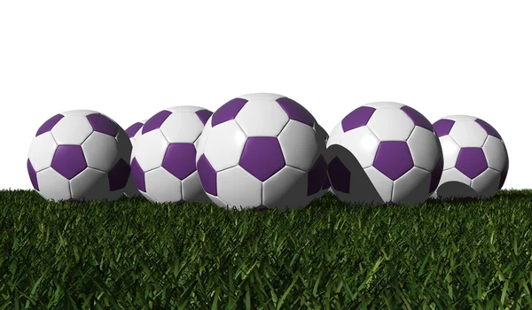 Фіолетові футбольні м'ячі на зеленій траві — стокове фото