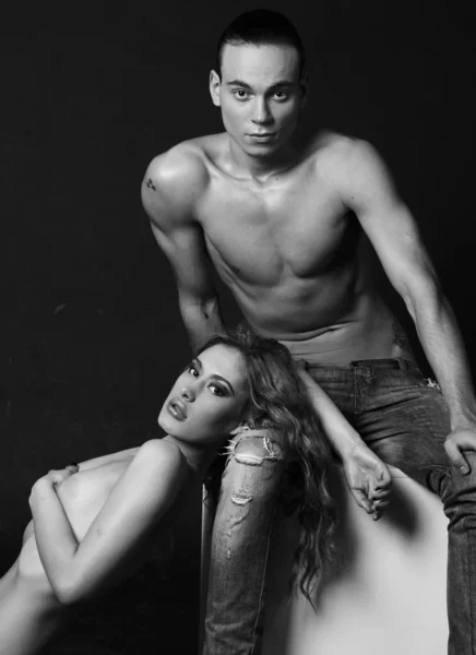 Leidenschaftliche sexuelle Fitness-Paar posiert halb nackt auf dunklen Rücken Stockbild