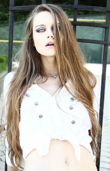 Portret van een mooie vrouwelijke model buitenshuis met lange haren pos — Stockfoto
