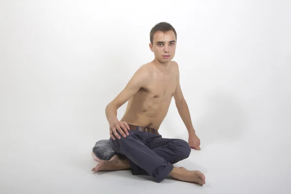Young handsome fitness sportsman doing yoga exercises isolated — Stock Photo, Image