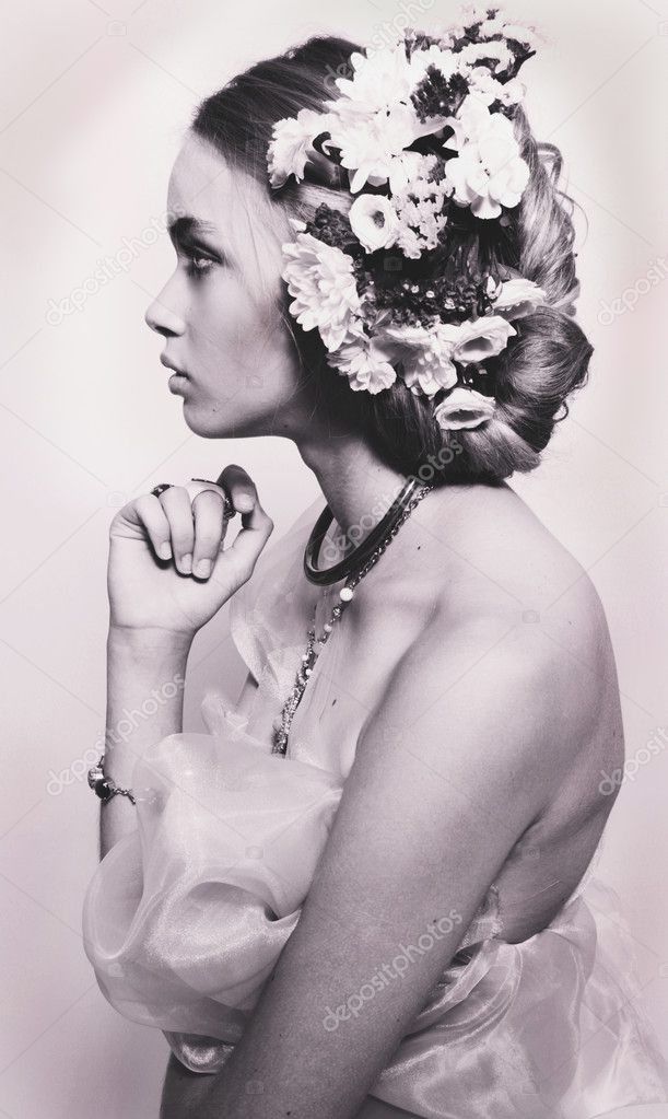 Profile portrait of beautiful teenage girl with flowers in hairs