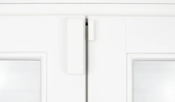 Czujnik bezprzewodowy alarm dla okien i drzwi na białe skrzydła drewniane — Zdjęcie stockowe