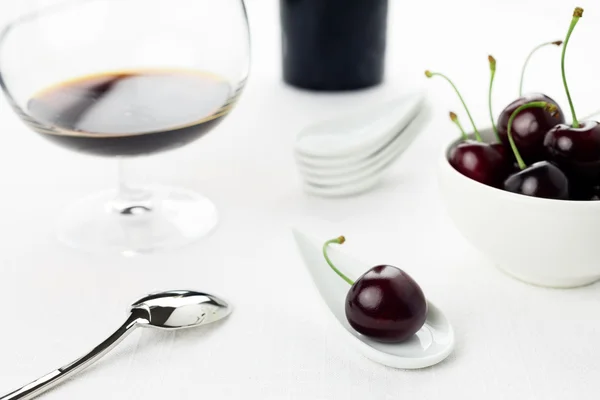 stock image Cherries on white spoon and bowl, sherry glass, sugar cane