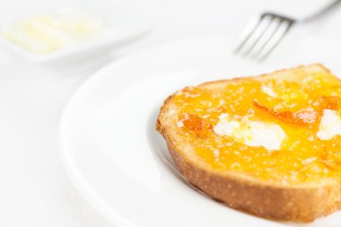 French toast close up, orange marmalade, butter, fork on white t clipart