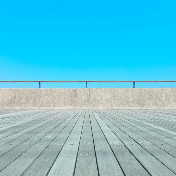 Balkon, dřevěné prkenné podlahy, betonový plot, modrá obloha. spodní pohled — Stock fotografie