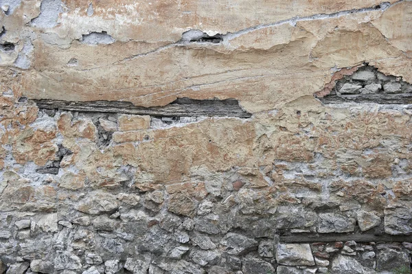 Alte rissige und verputzte Steinmauer — Stockfoto
