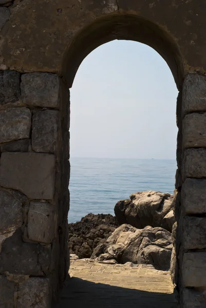 Старая арка с морем и скалами в Чефалу — стоковое фото