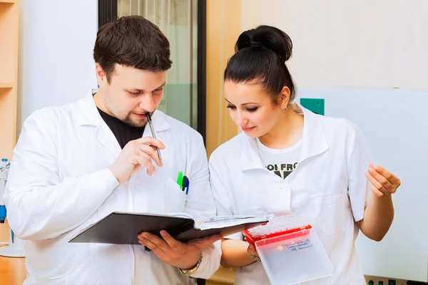 Two scientists with lab journal — Stock Photo, Image
