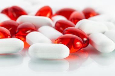 Vitamin hapları: kırmızı kapsül ve beyaz sekmeleri