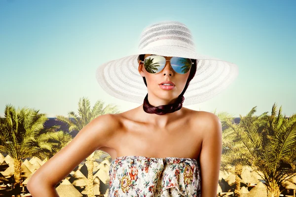 Sexy donna bruna con occhiali da sole, cappello e abito modello floreale Immagini Stock Royalty Free