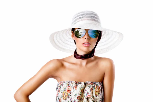 Sexy donna bruna con occhiali da sole bianco cappello estivo e abito modello floreale Immagine Stock