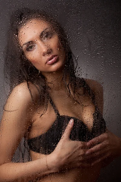 黑色的胸罩和淋湿的玻璃是牛仔裤的女孩. — 图库照片