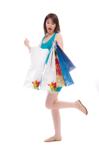 Beautiful girl in the blue bags to shoppers on a white background. — Stock Photo, Image