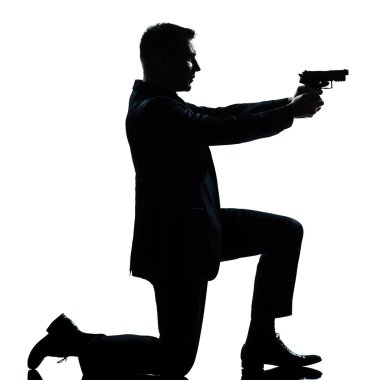 Silhouette man kneeling aiming gun clipart