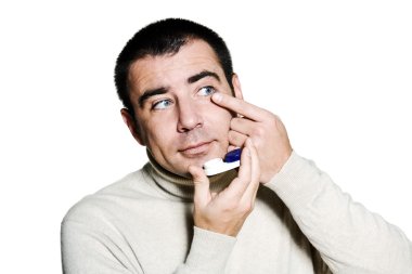 Man inserting a contact lens in his eye clipart