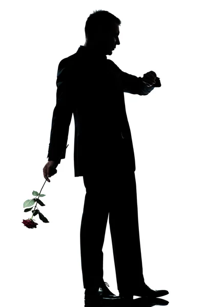 Silueta muže plné délce, jeden bělošský držení růže květ — Stock fotografie