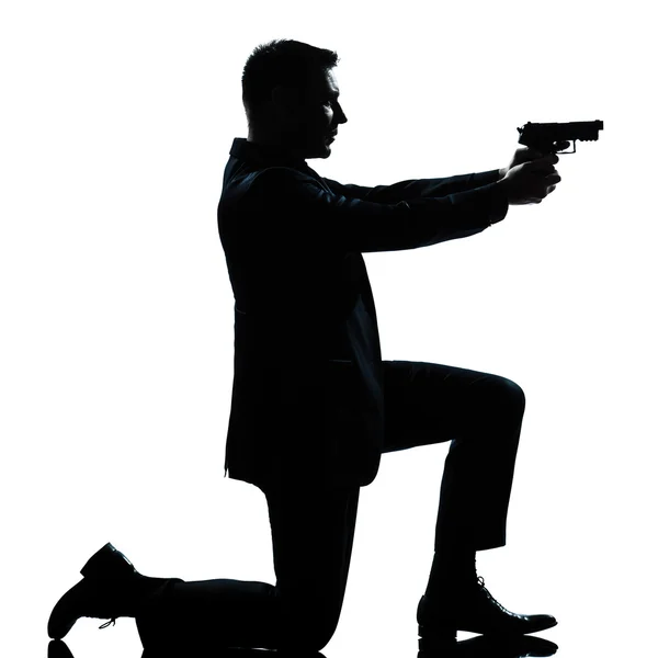 Sylwetka człowieka klęcząc pistolet mające — Zdjęcie stockowe