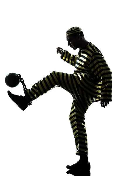 Человек преступник, играющий в футбол с цепным мячом — стоковое фото