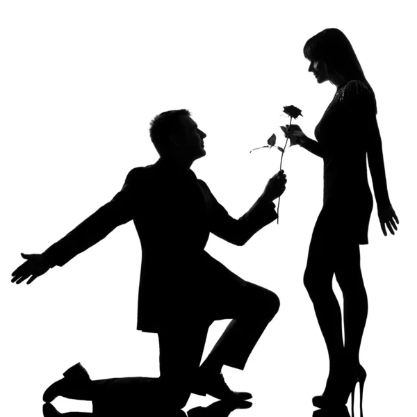 Um casal homem ajoelhado oferecendo rosa flor e mulher sorrindo — Fotografia de Stock