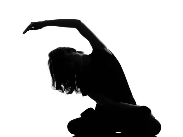Silhouette woman sitting exercising yoga — Stock Photo, Image