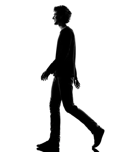 Gülümseyerek yürüyen genç adam siluet — Stok fotoğraf