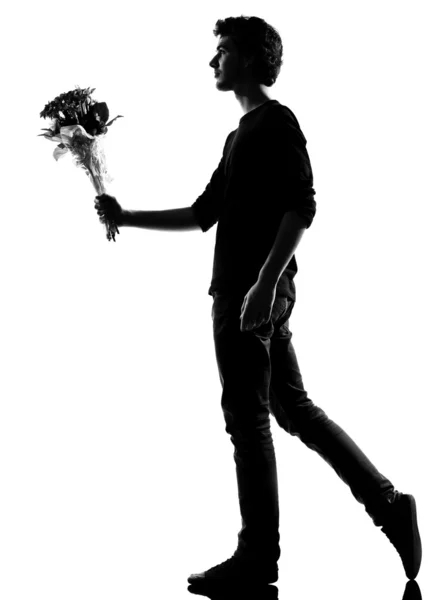 Young man silhouette offering flowers bouquet — Stock Photo, Image